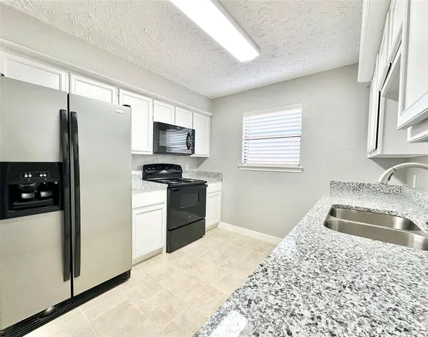 a kitchen with a refrigerator stove and sink