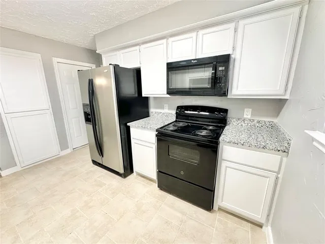 a kitchen with a refrigerator stove and microwave