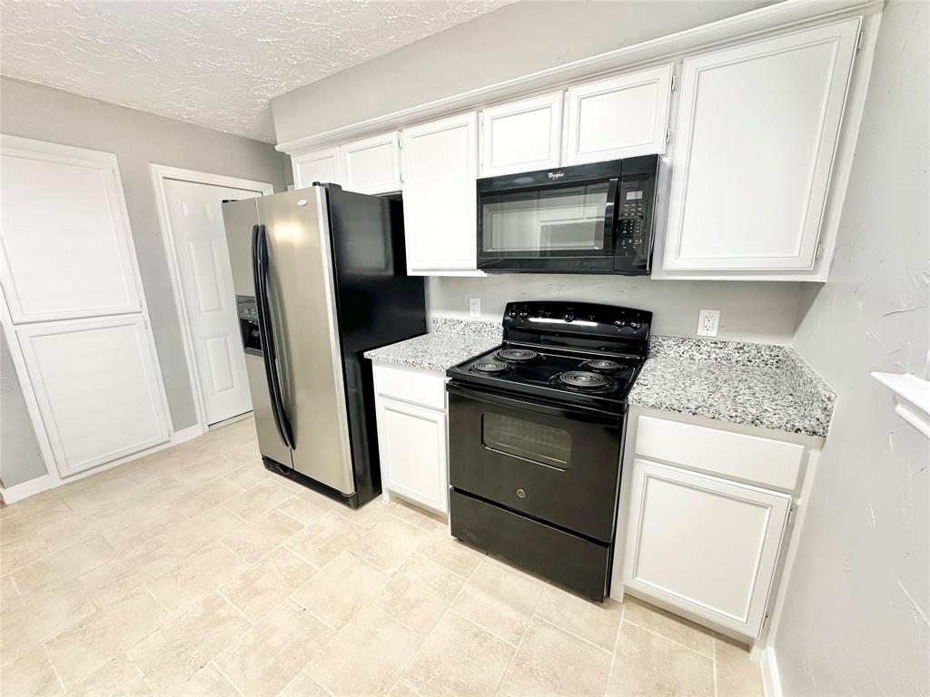 1002 Bull Run Street Denton, TX 76209 - Photo 12 of 21 a kitchen with a refrigerator stove and microwave