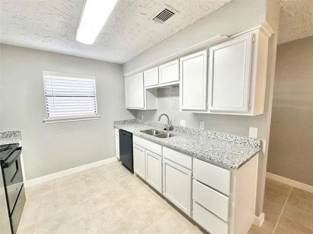 a kitchen with granite countertop white cabinets and white appliances