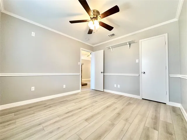 wooden floor in an empty room with a ceiling fan