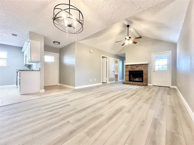 a view of empty room with a fireplace and fan