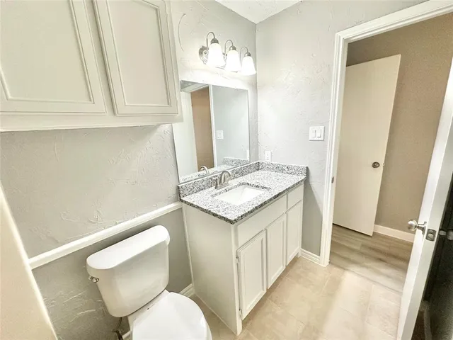 a bathroom with a sink a toilet and mirror