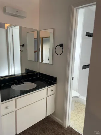 a bathroom with a granite countertop sink and a mirror