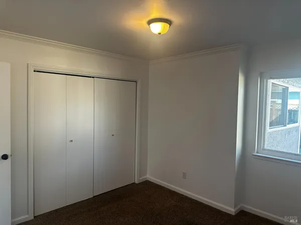 an empty room with windows and closet