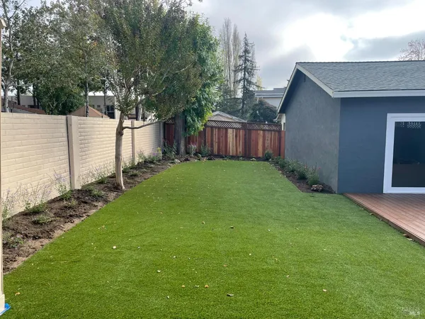 a view of a backyard with potted plants and wooden fence