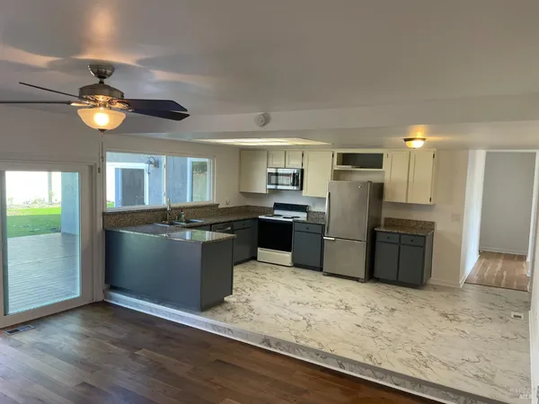a kitchen with stainless steel appliances granite countertop a refrigerator and a stove top oven