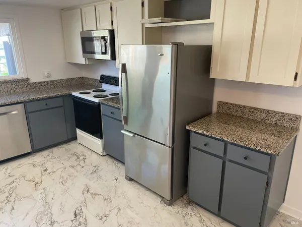 a kitchen with stainless steel appliances granite countertop a refrigerator sink and stove