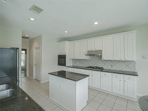 a kitchen with white cabinets sink and stainless steel appliances