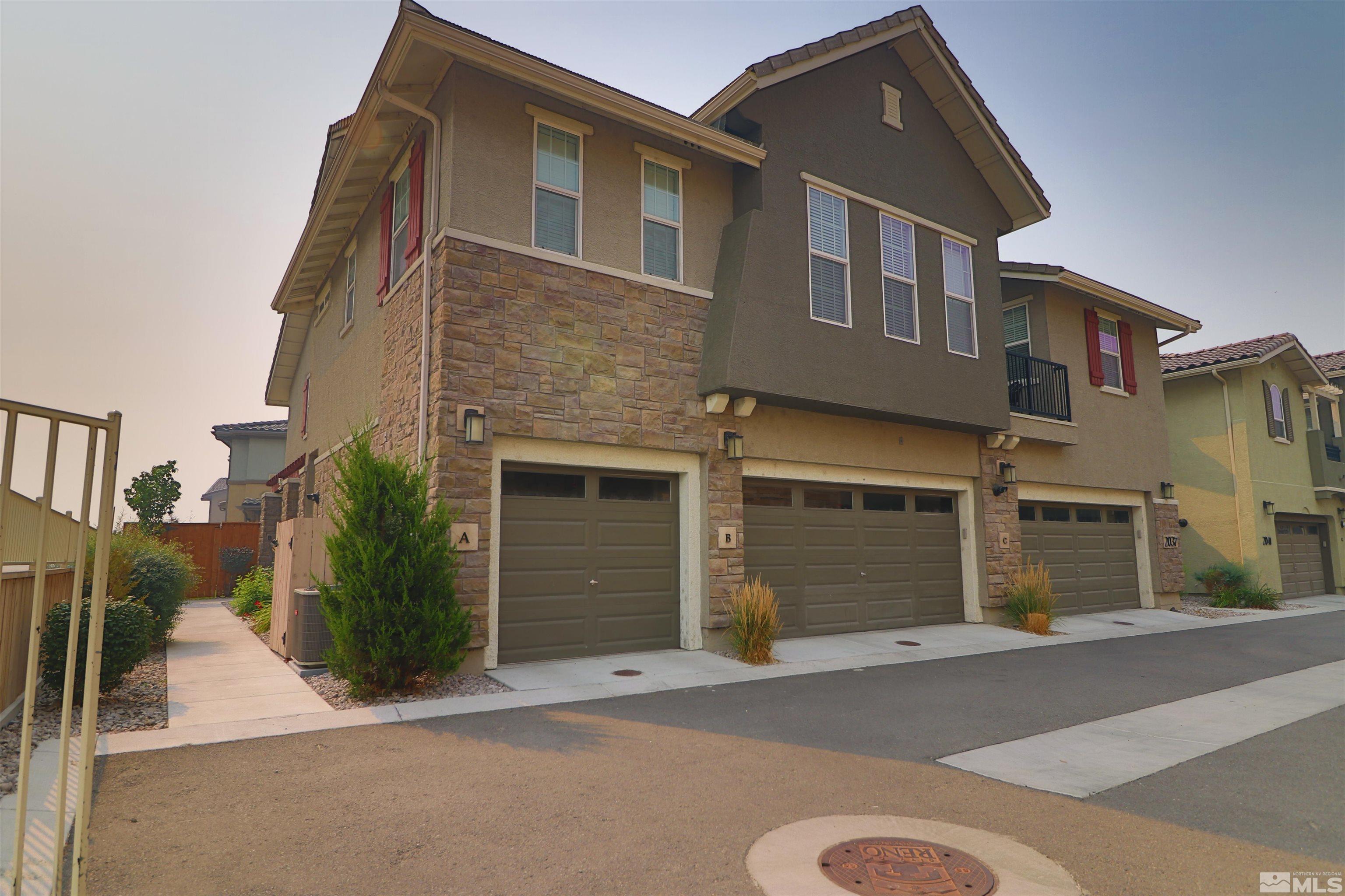 2037 Wind Ranch Road, Unit B Reno, NV 89521 - Photo 1 of 21 a front view of a house with a yard and garage