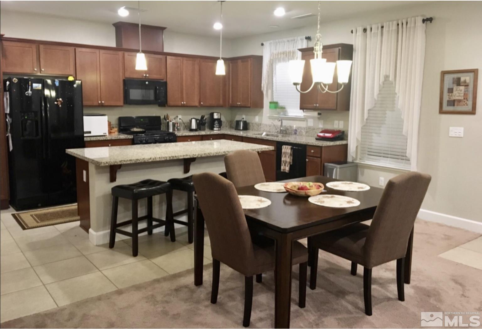 2037 Wind Ranch Road, Unit B Reno, NV 89521 - Photo 7 of 21 a kitchen with a dining table chairs and refrigerator