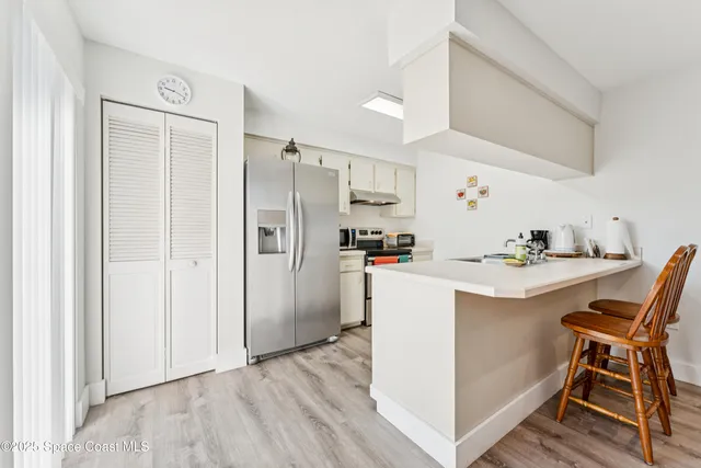 a kitchen with kitchen island white cabinets and stainless steel appliances