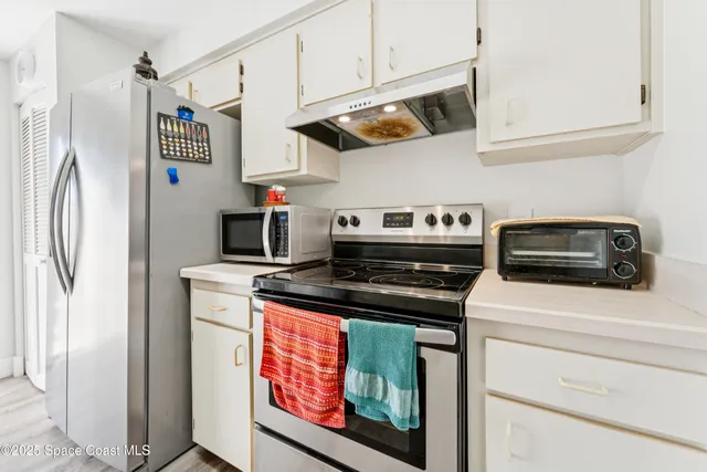 a kitchen with stainless steel appliances granite countertop a stove and a refrigerator