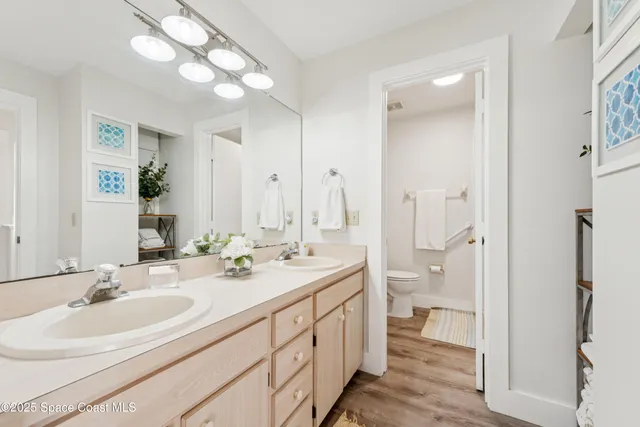 a bathroom with a double vanity sink mirror and toilet