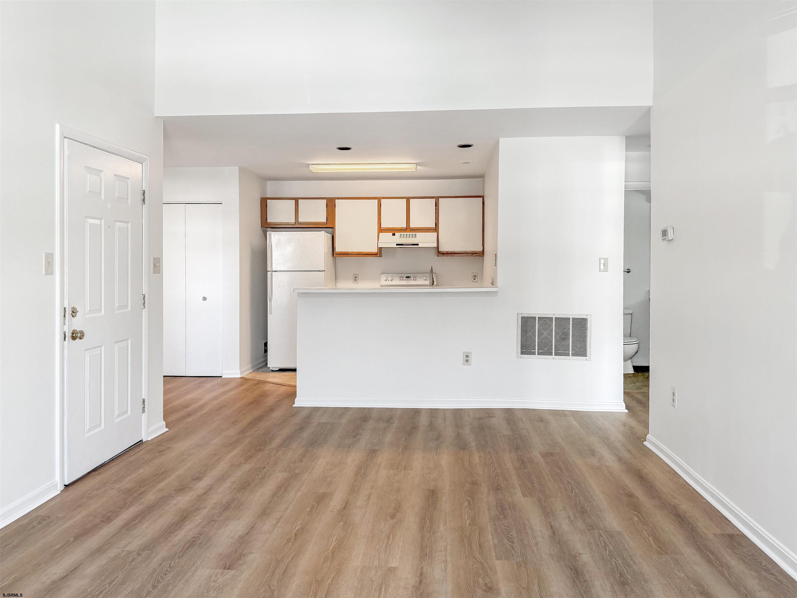 132 Meadow Ridge Road, Unit 132 Smithville, NJ 08205 - Photo 2 of 7 wooden floor in an empty room with a window