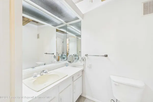 a bathroom with a sink a mirror and a toilet