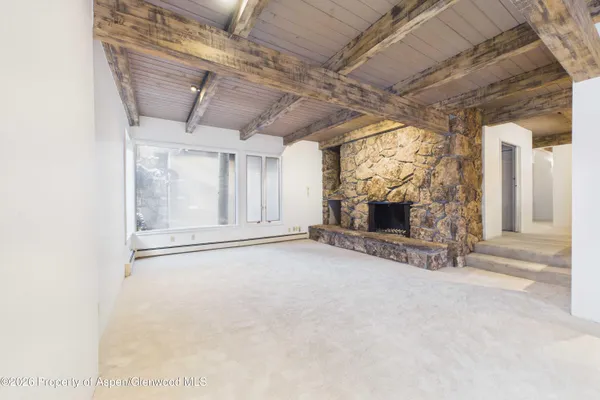 a view of empty room with fireplace and windows