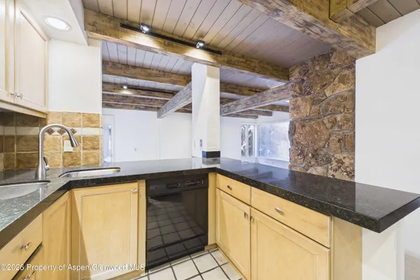 a kitchen with granite countertop a sink and cabinets