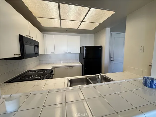 a kitchen with a refrigerator and a stove top oven
