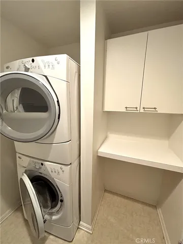 a view of empty room with windows and refrigerator