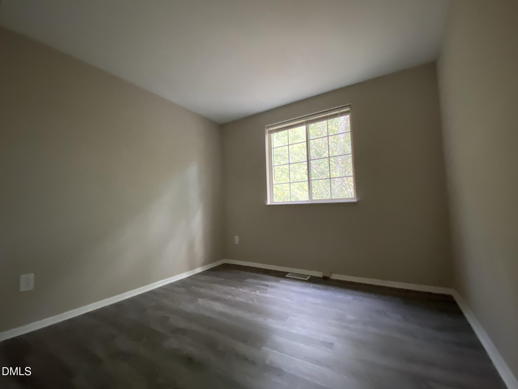 7708 Crown Crest Court Raleigh, NC 27615 - Photo 13 of 27 an empty room with wooden floor and windows