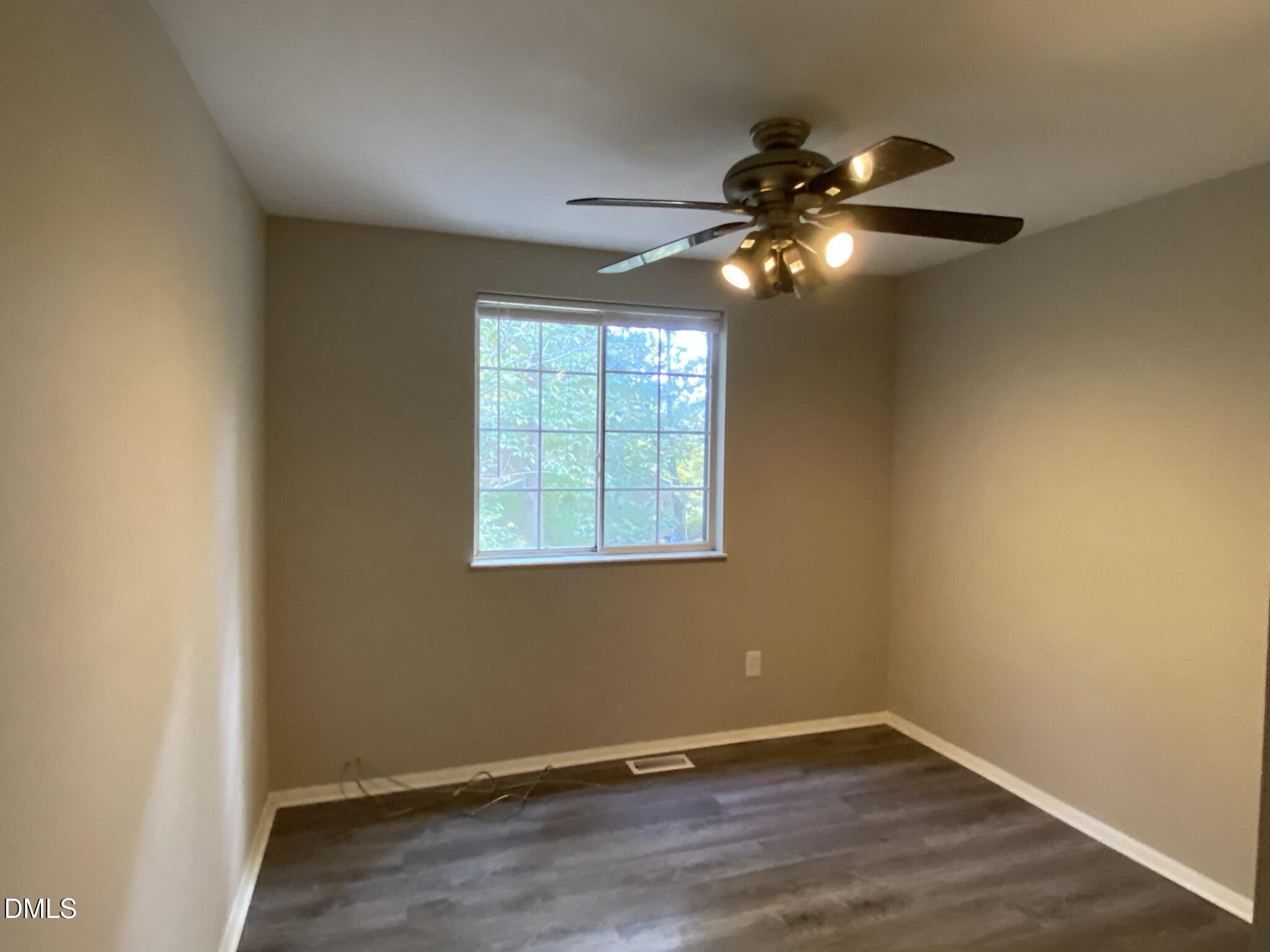 7708 Crown Crest Court Raleigh, NC 27615 - Photo 20 of 27 a view of an empty room with wooden floor and a window