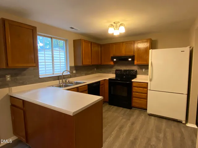 a kitchen with a sink a stove a refrigerator and a oven