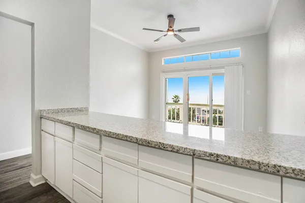 a living room with granite countertop furniture a ceiling fan a window and a ceiling fan