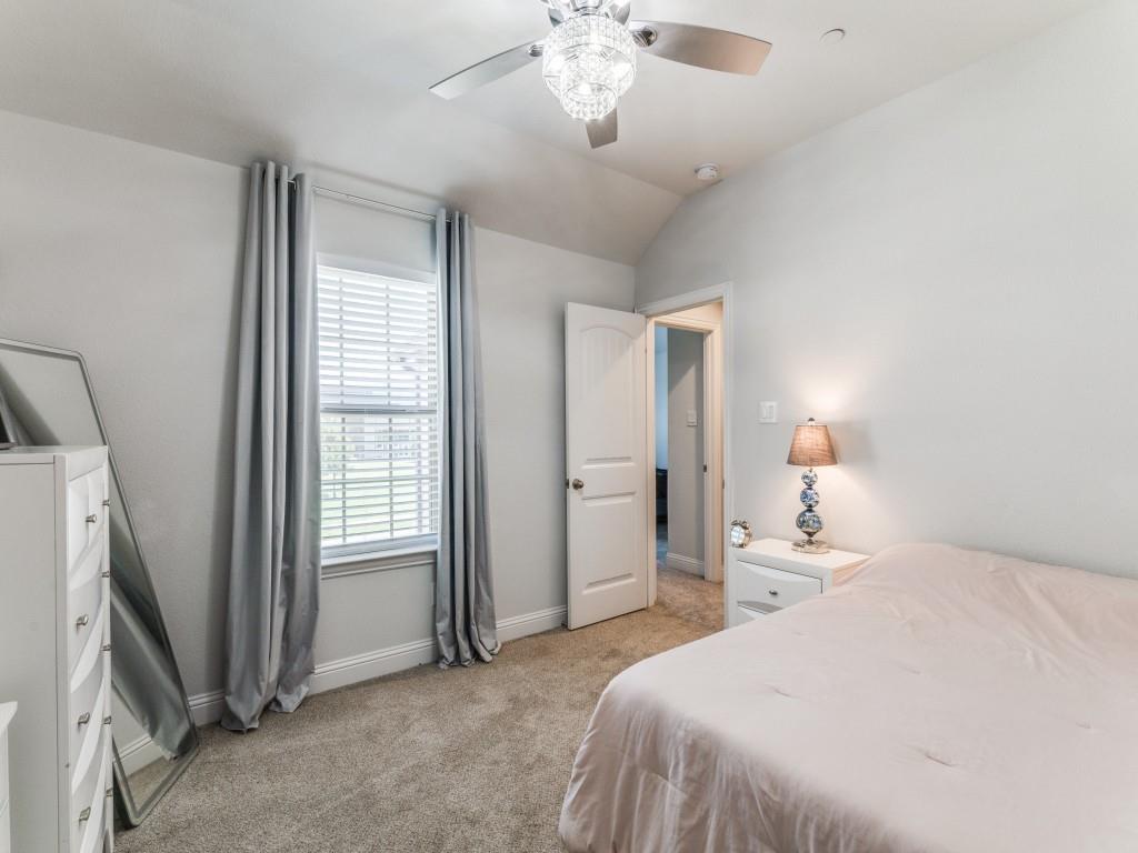5944 Bursey Road Watauga, TX 76148 - Photo 21 of 25 a bedroom with a bed and a chandelier