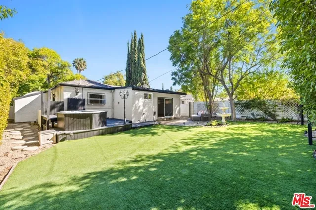 a view of a house with a big yard and large tree