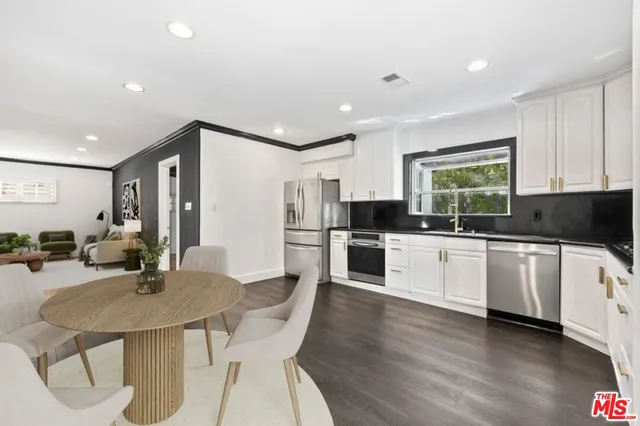 a kitchen with granite countertop white cabinets and stainless steel appliances