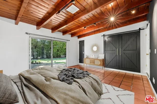 a bedroom with a bed and a large window with the outer view