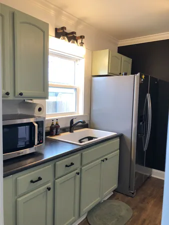 a kitchen with stainless steel appliances a sink cabinets and a window