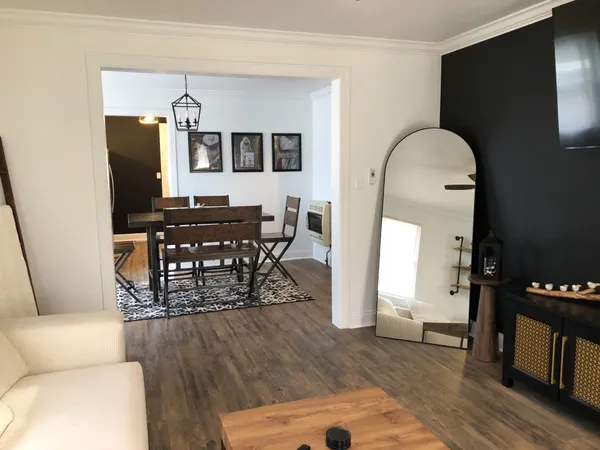 a living room with furniture a wooden floor and a dining table