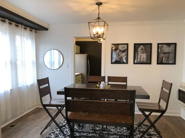 a view of a dining room with furniture and chandelier