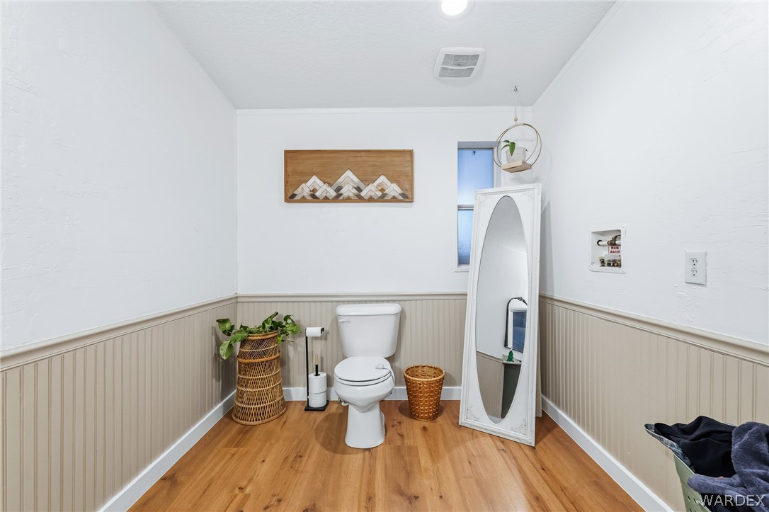 1996 Ramar Road Bullhead City, AZ 86442 - Photo 22 of 65 This bathroom features beadboard paneling, light wood-style flooring, and a window providing natural light