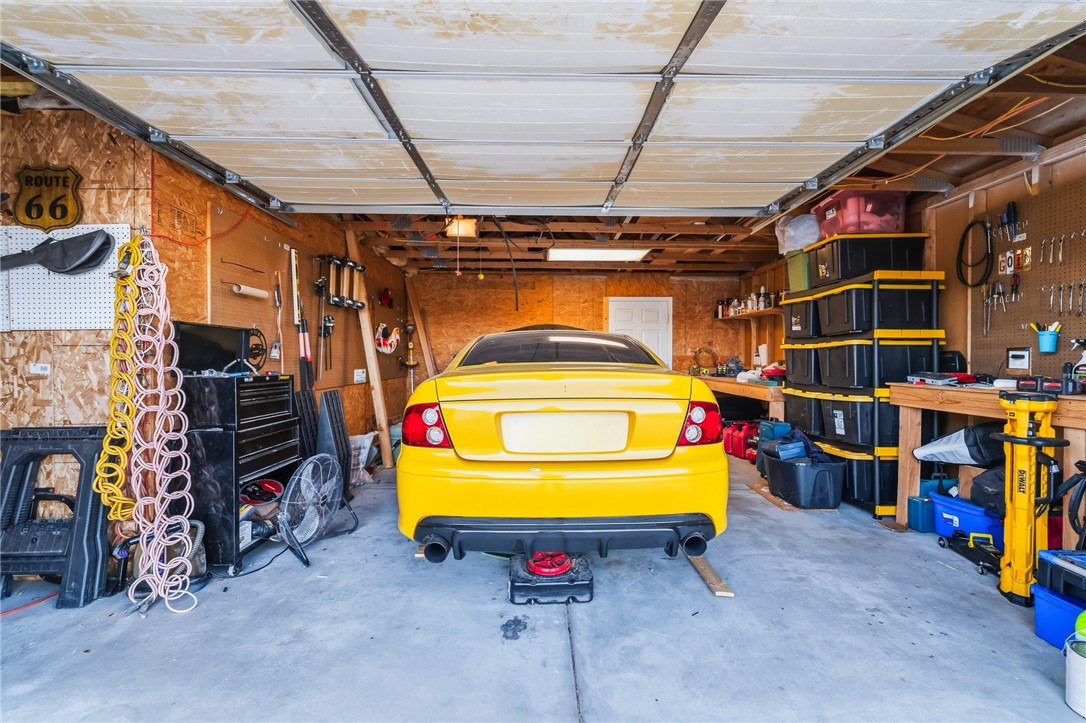 1996 Ramar Road Bullhead City, AZ 86442 - Photo 43 of 65 This garage features a concrete floor, exposed wood beam ceiling, and ample wall storage, including shelving and pegboards