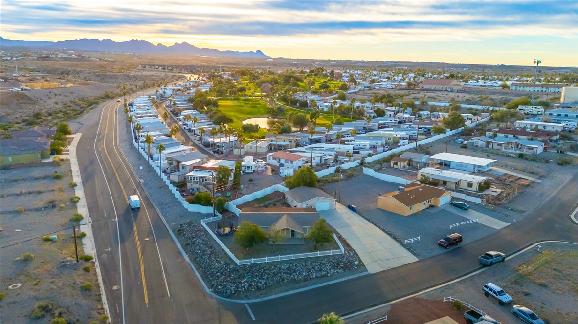 1996 Ramar Road Bullhead City, AZ 86442 - Photo 55 of 65 Aerial view of the property and its surrounding community, featuring paved roads, mountainous terrain in the distance, and nearby golf course