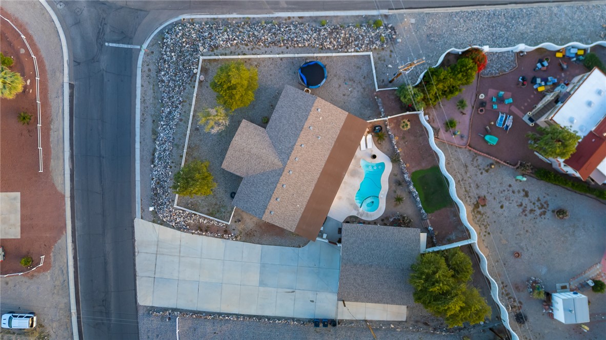 1996 Ramar Road Bullhead City, AZ 86442 - Photo 60 of 65 This property features a swimming pool with a unique shape, a spacious driveway, and a well-maintained roof