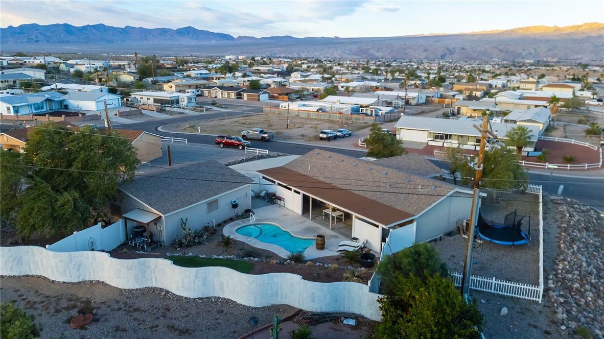 1996 Ramar Road Bullhead City, AZ 86442 - Photo 64 of 65 The property features an outdoor swimming pool, a covered patio, and a white picket fence