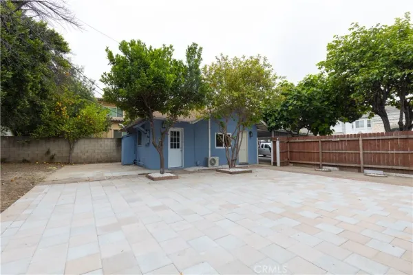 a view of a house with a tree and wooden fence
