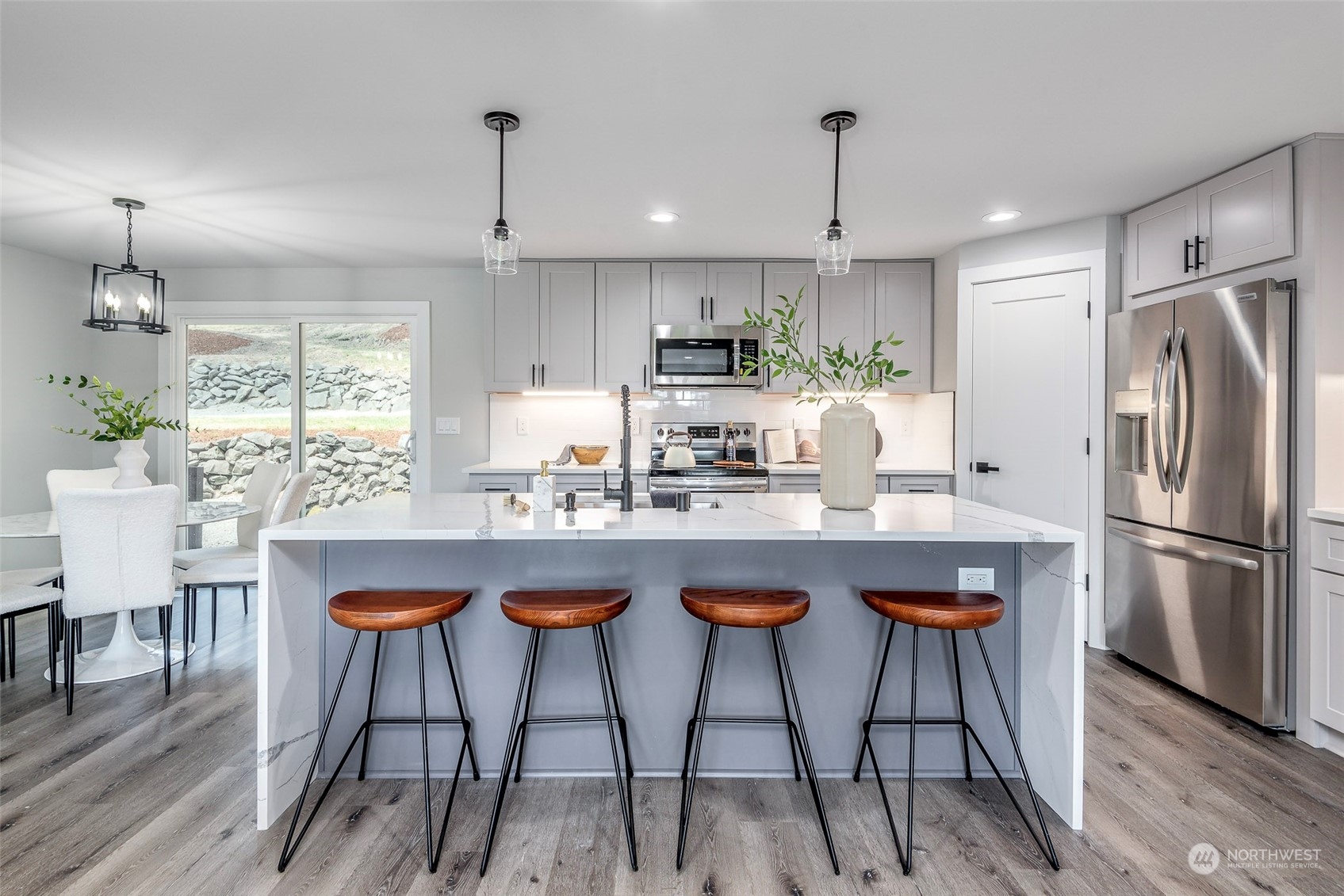 1582 Rainier Drive Fircrest, WA 98466 - Photo 11 of 40 a kitchen with stainless steel appliances granite countertop a dining table chairs refrigerator and cabinets