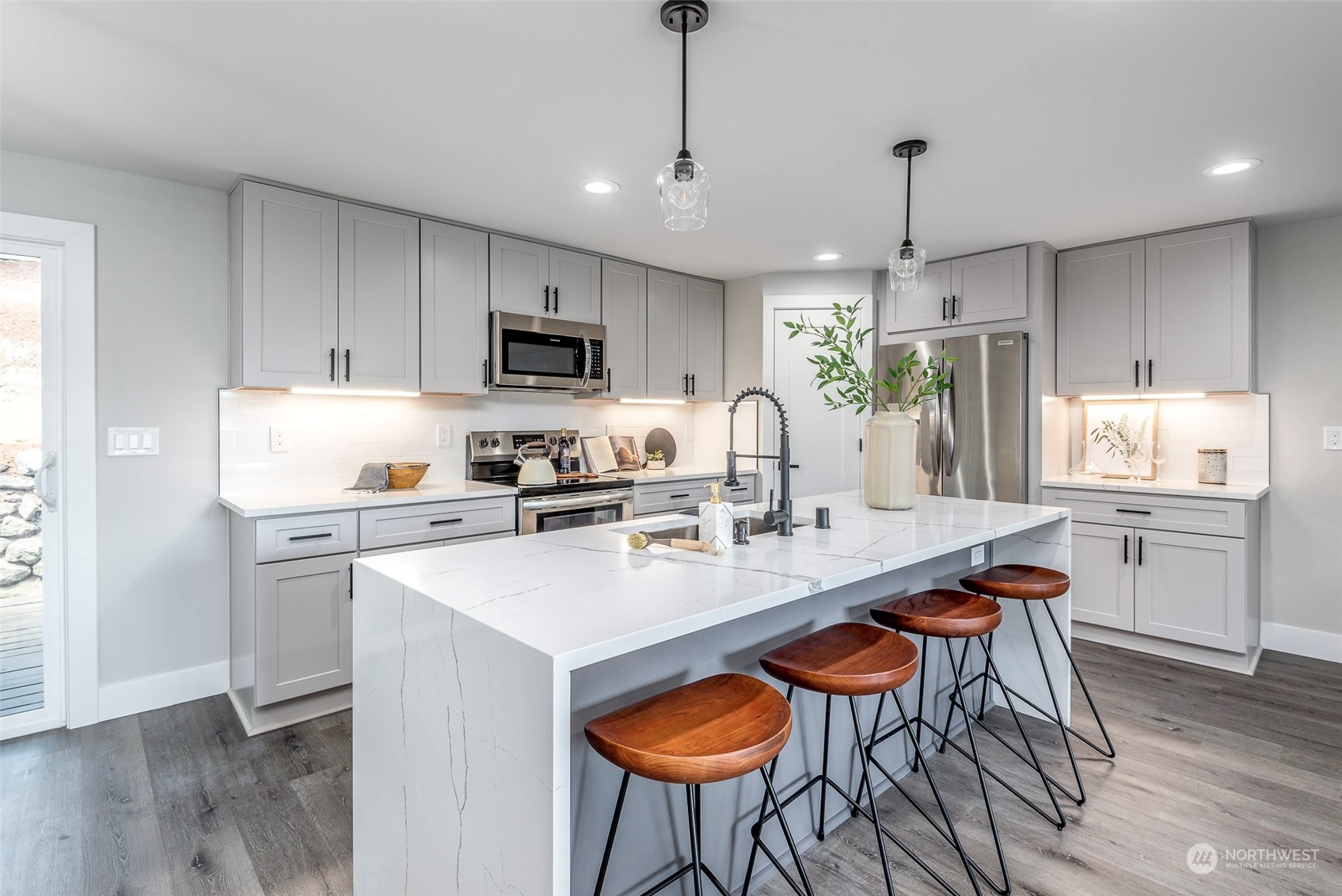 1582 Rainier Drive Fircrest, WA 98466 - Photo 12 of 40 a kitchen with stainless steel appliances granite countertop a kitchen island a stove a table and chairs in it