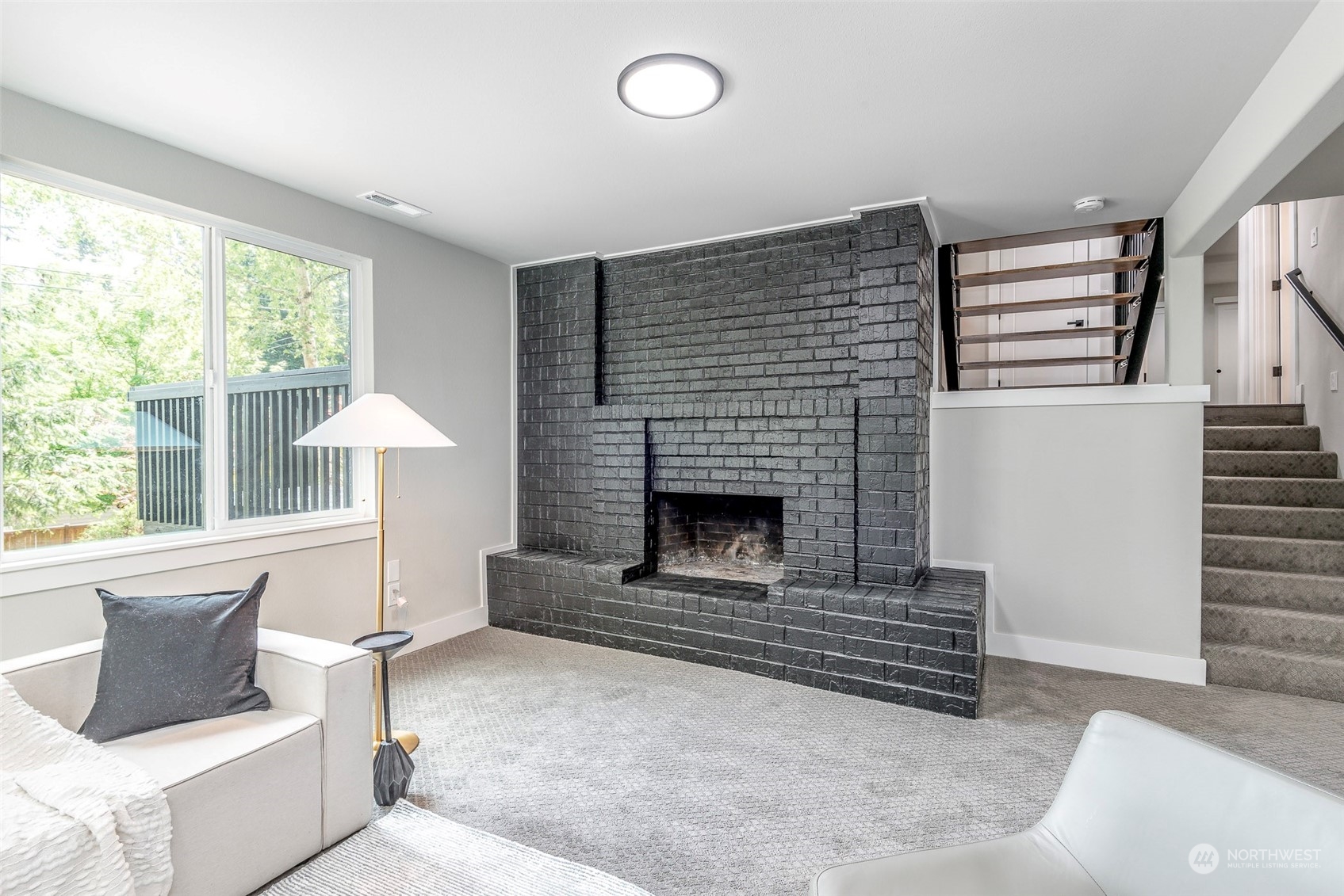 1582 Rainier Drive Fircrest, WA 98466 - Photo 24 of 40 a living room with furniture a fireplace and a large window