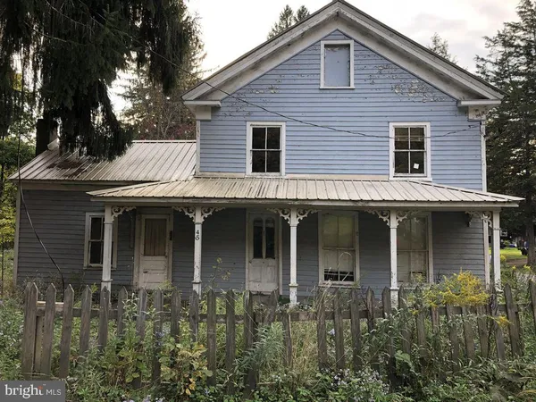 a front view of a house with plants and trees