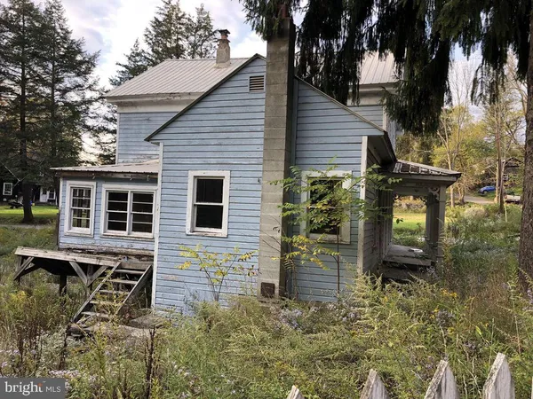an aerial view of house with yard and mountain view in back