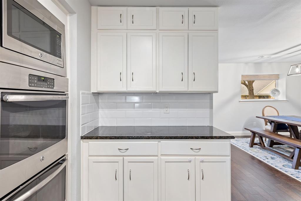 15935 Longvista Drive Dallas, TX 75248 - Photo 13 of 27 a kitchen with granite countertop white cabinets and white appliances