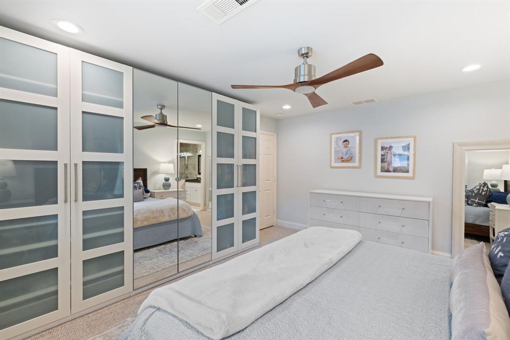 15935 Longvista Drive Dallas, TX 75248 - Photo 15 of 27 a spacious bedroom with a bed and a view of closet