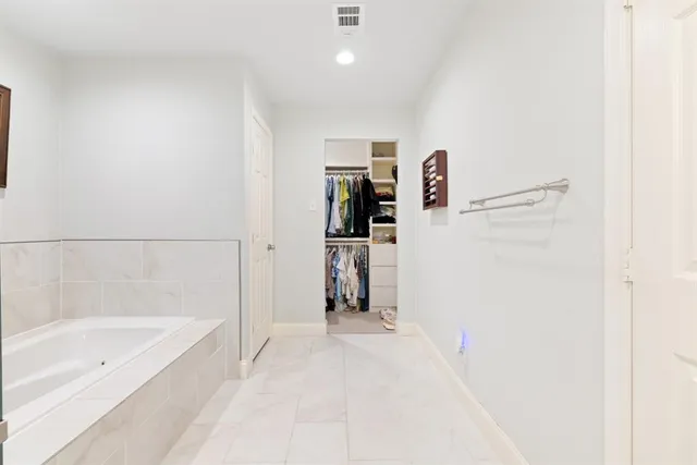 a spacious bathroom with a granite countertop sink a mirror a bathtub and a shower