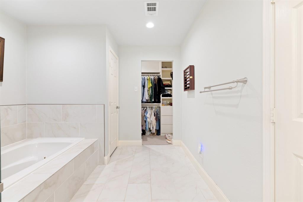 15935 Longvista Drive Dallas, TX 75248 - Photo 17 of 27 a bathroom with a bathtub and a shower